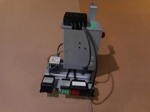 Verdrahtungseinheit von Remeha mit mehreren Anschlussklemmen und Leitungen. Sichtbare Komponenten umfassen Stecker, Schalter und verdrahtete Module auf einem montierten Träger.
